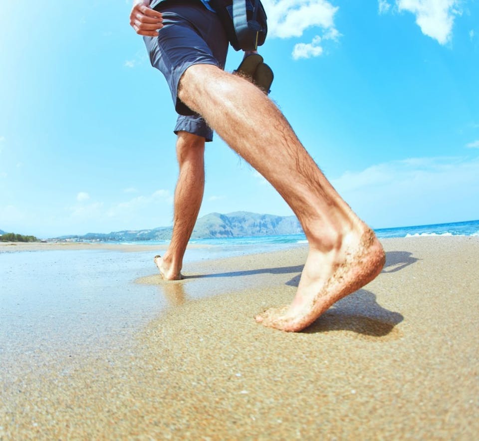A man striding along the beach